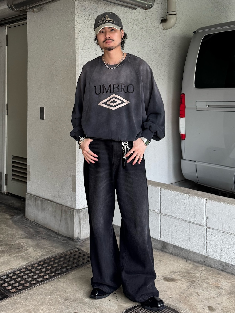 グレー系のスウェット、ブラック系のデニムパンツを着用したメンズの春コーディネートの1枚目の写真