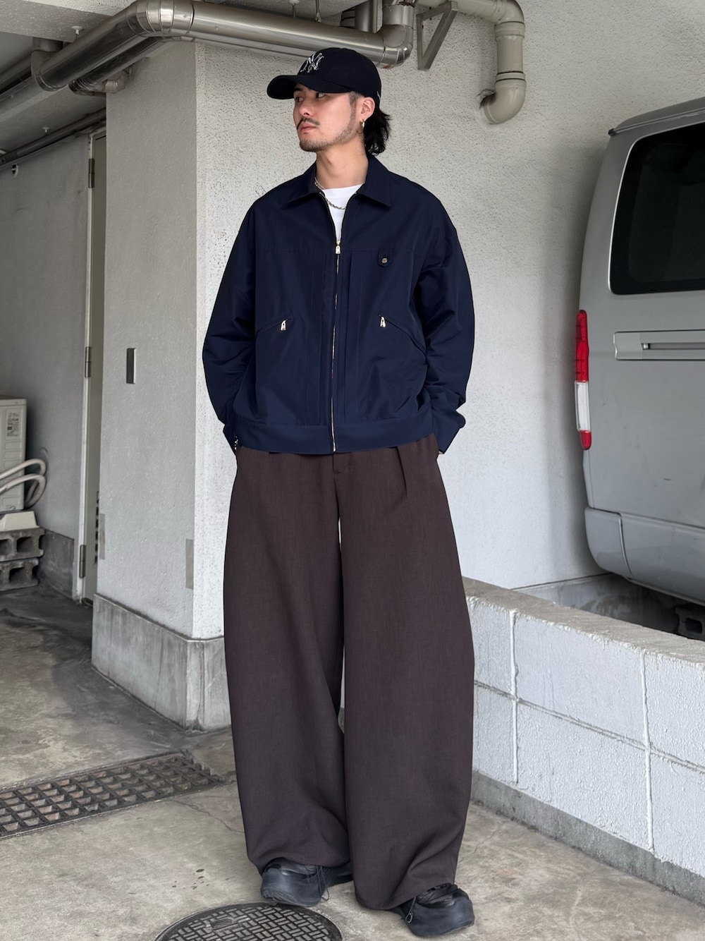 ブルー系のブルゾン、グレー系のスラックスを着用したメンズの春コーディネートの1枚目の写真