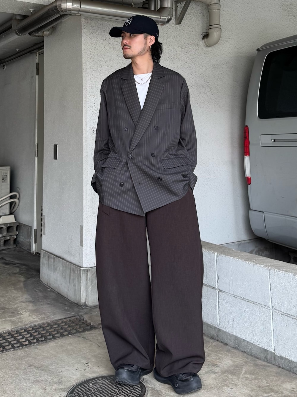 グレー系のテーラードジャケット、グレー系のスラックス、ホワイト系のTシャツ/カットソーを着用したメンズの春コーディネートの1枚目の写真