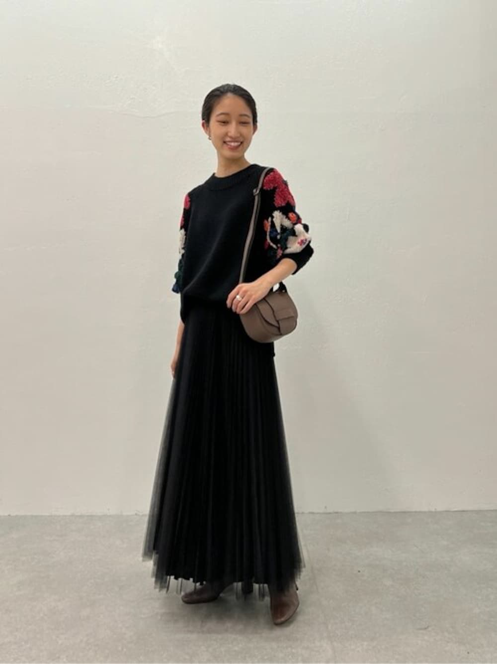 ブラック系のニット/セーター、ブラック系のスカートを着用したレディースの夏コーディネートの1枚目の写真