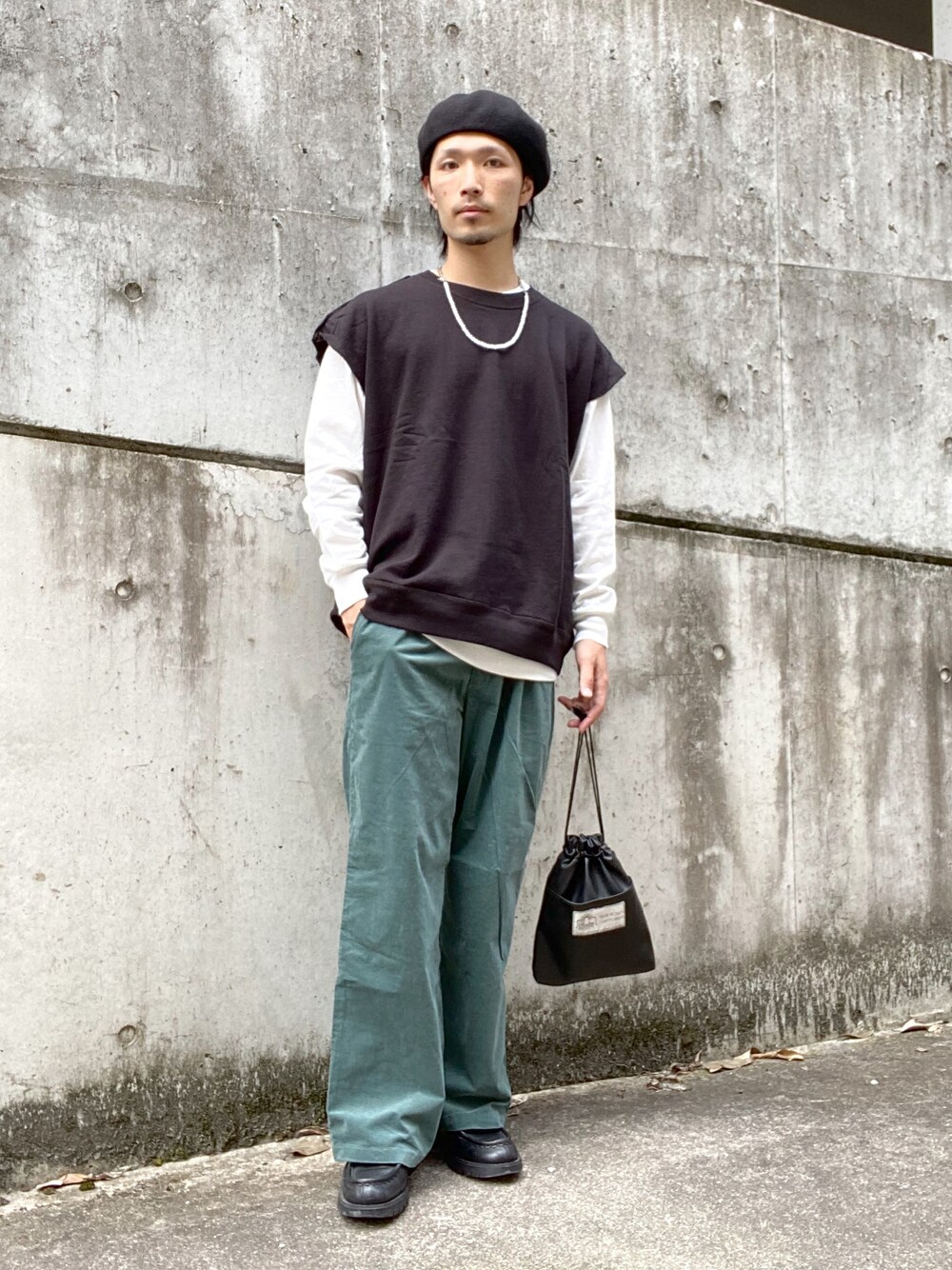 グリーン系のスラックス、その他のショルダーバッグ、ブラック系のTシャツ/カットソーを着用したメンズの秋コーディネートの1枚目の写真