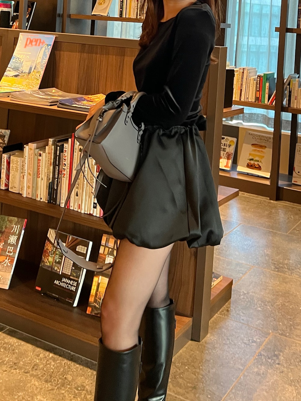 ブラック系のTシャツ/カットソー、ブラック系のブーツ、ブルー系のノーカラーコートを着用したレディースの秋コーディネートの1枚目の写真