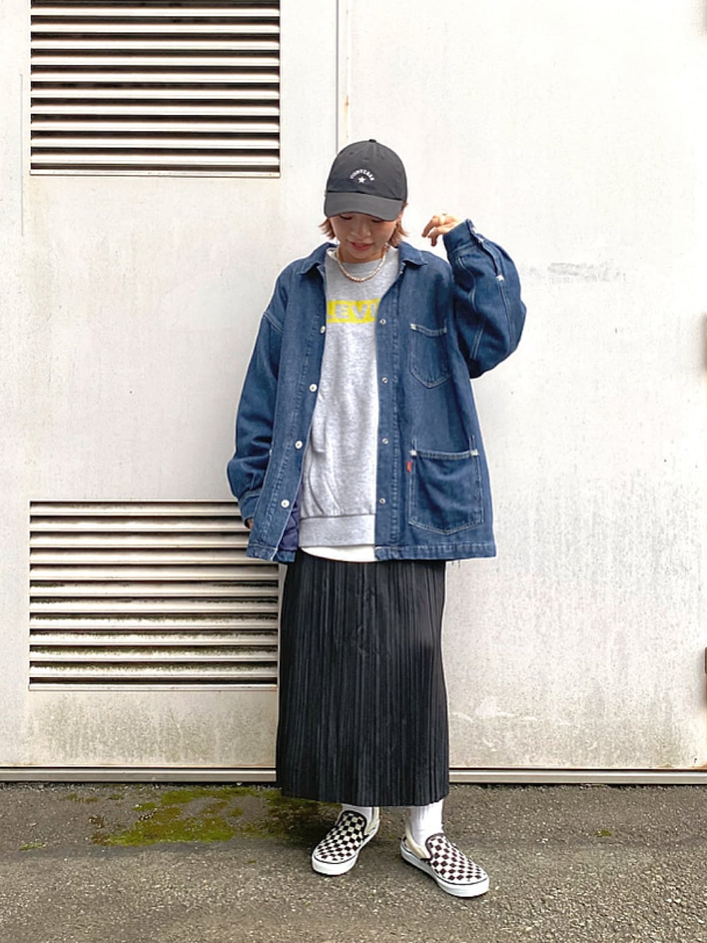 ブラック系のスカート、グレー系のスウェット、ホワイト系のスリッポンを着用したレディースの秋コーディネートの1枚目の写真