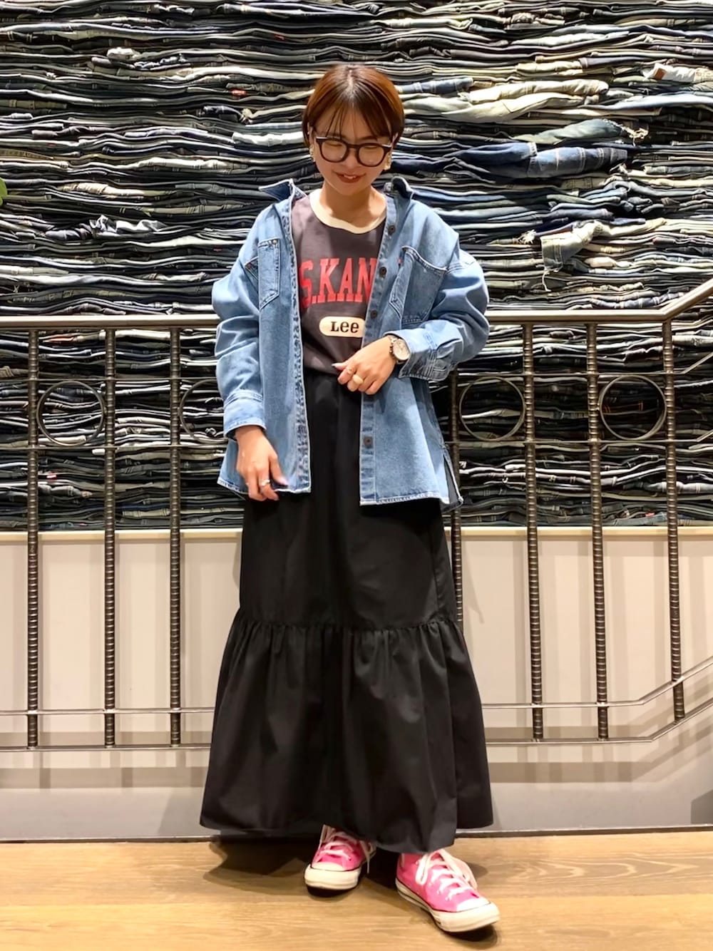 ブラック系のスカート、ブルー系のシャツ/ブラウス、グレー系のTシャツ/カットソーを着用したレディースの春コーディネートの1枚目の写真