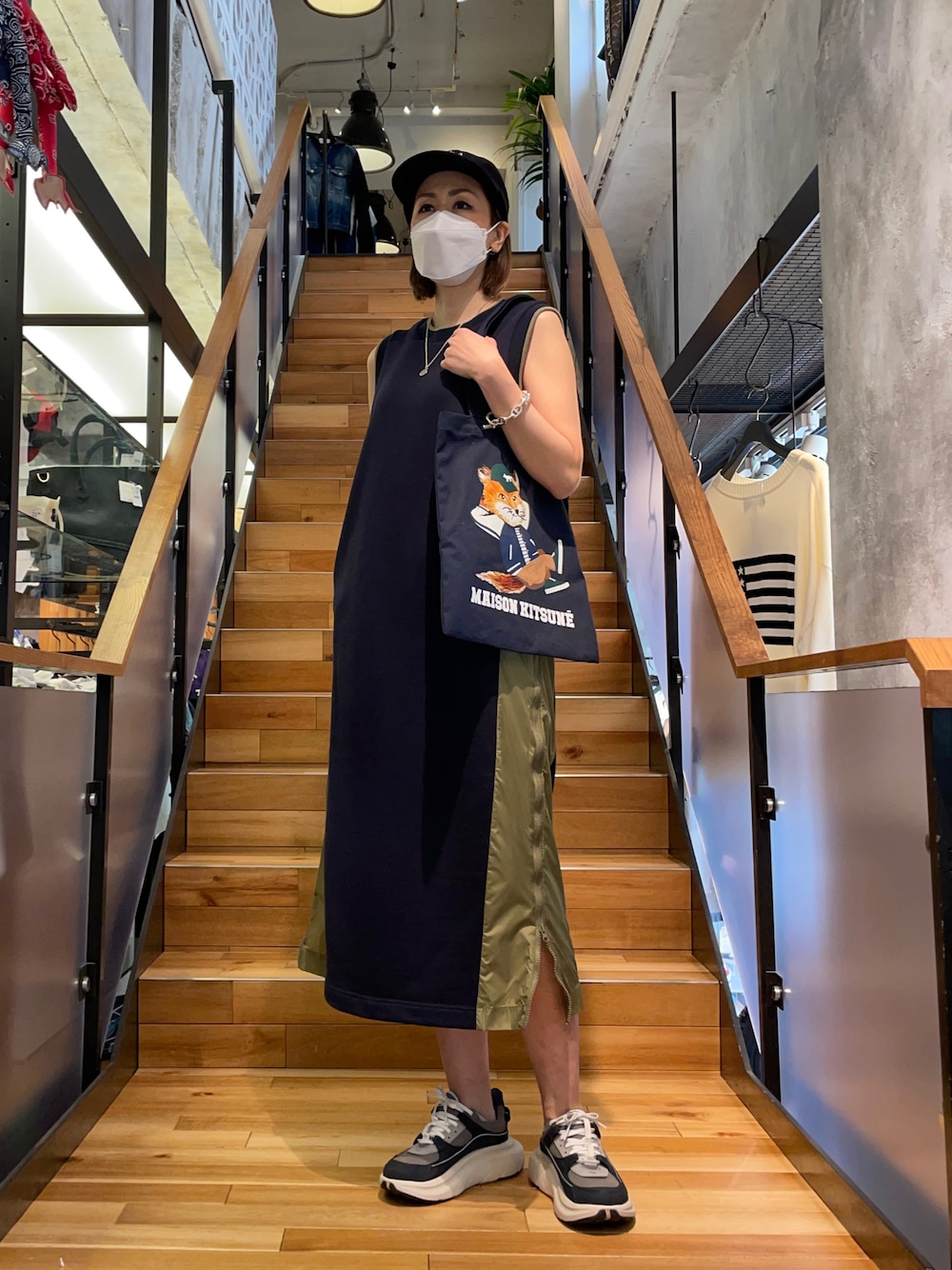 レッド系のワンピース/ドレス、ブルー系のトートバッグ、ブルー系のキャップを着用したレディースの春コーディネートの1枚目の写真