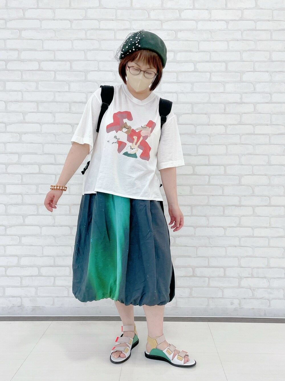 ブラック系のバックパック/リュック、ホワイト系のTシャツ/カットソー、ブラック系のスカートを着用したレディースの夏コーディネートの1枚目の写真