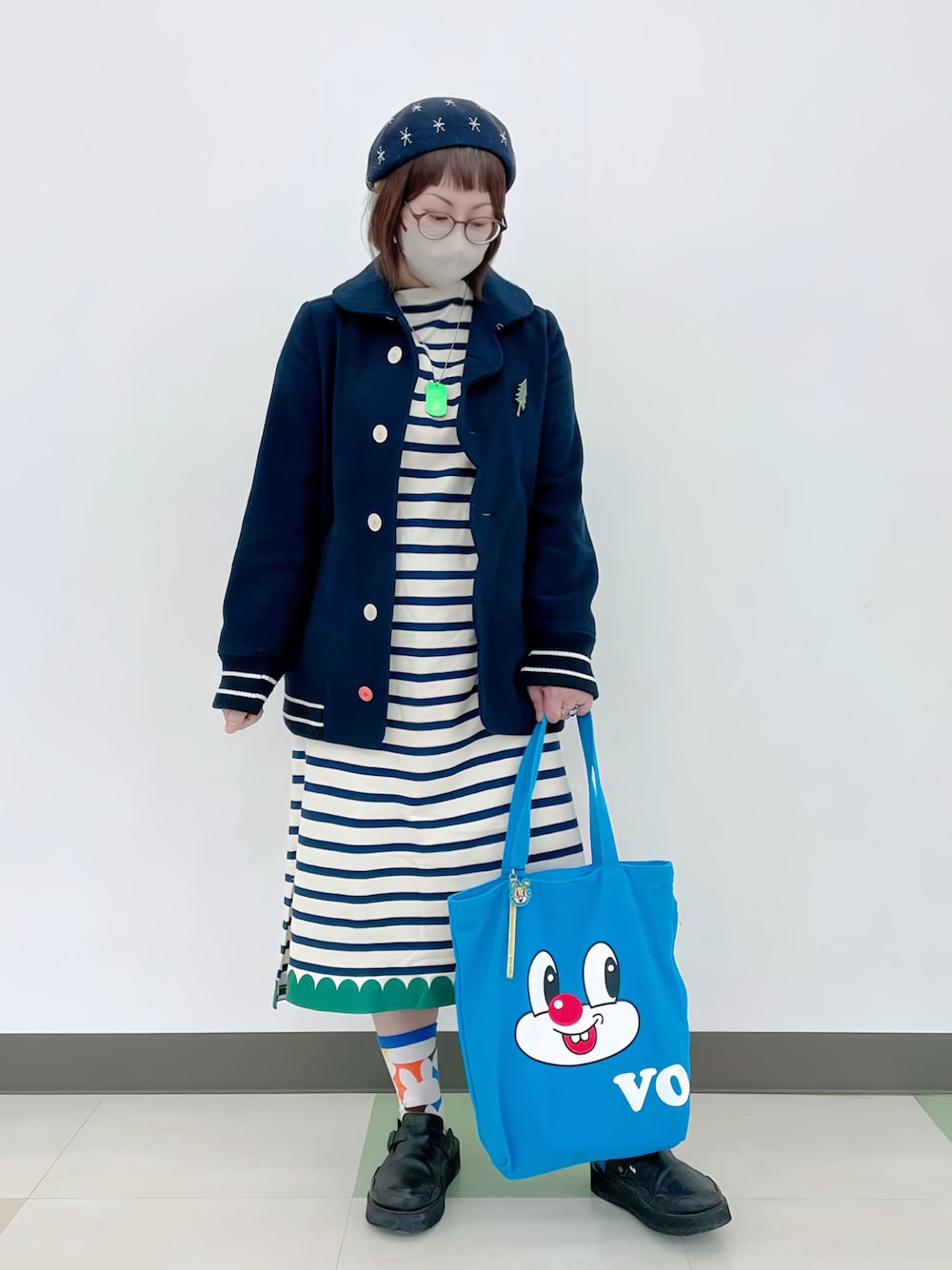 ブルー系のピーコート、ホワイト系のワンピース、ブルー系のトートバッグを着用したレディースの春コーディネートの1枚目の写真