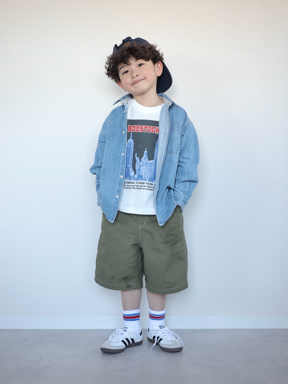 グリーン系のパンツ、ホワイト系のスニーカー、ホワイト系のTシャツ/カットソーを着用したキッズの春コーディネートの1枚目の写真