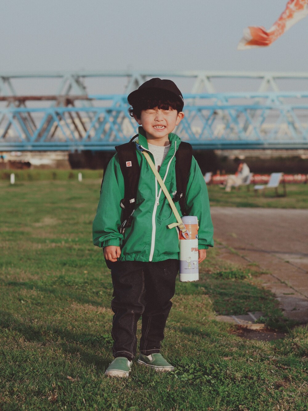 グリーン系のブルゾン、ブルー系のデニムパンツ、グリーン系のスニーカーを着用したキッズの春コーディネートの1枚目の写真