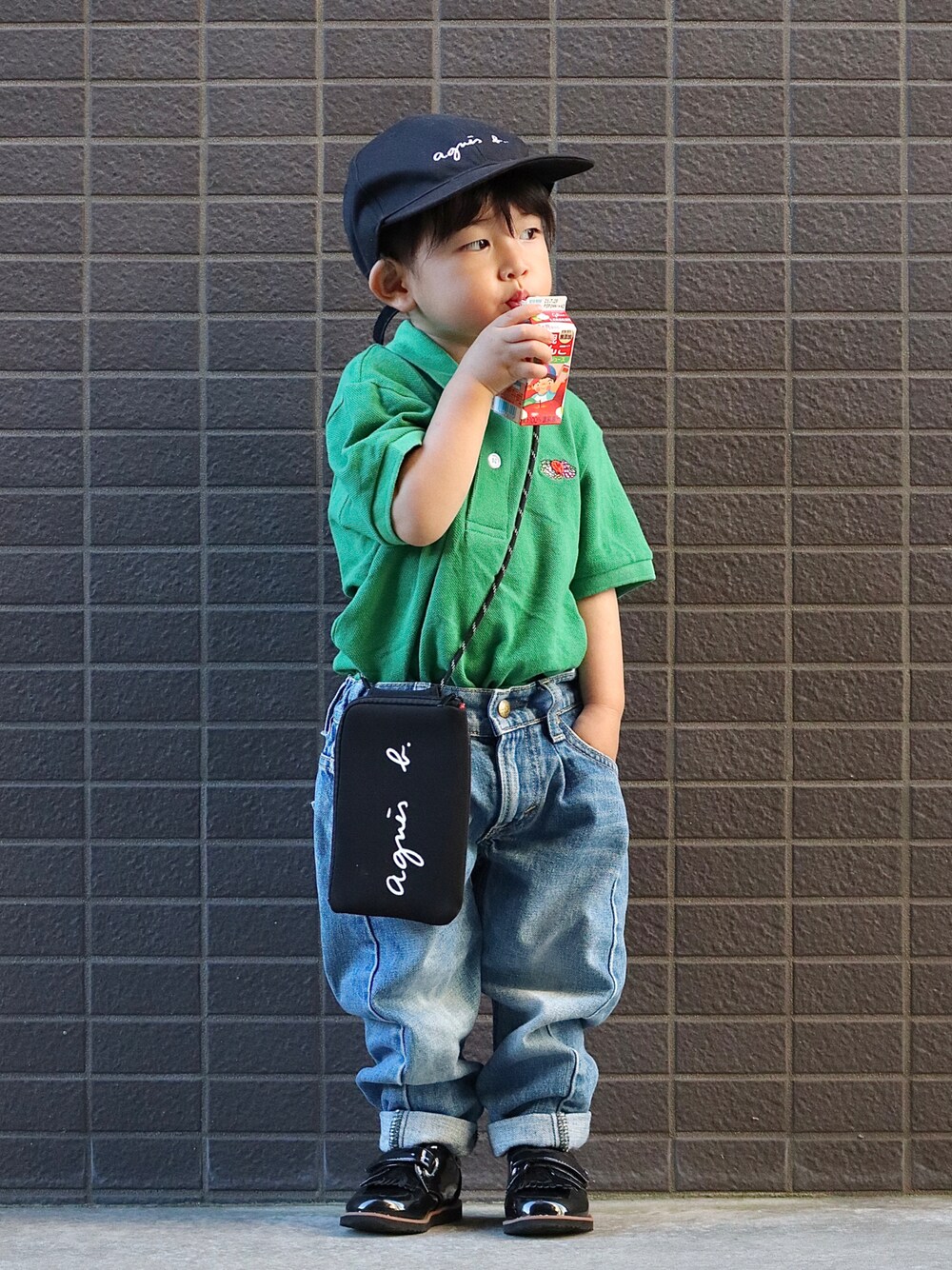 グリーン系のポロシャツ、ブルー系のデニムパンツ、ブラック系のシューズを着用したキッズの夏コーディネートの1枚目の写真