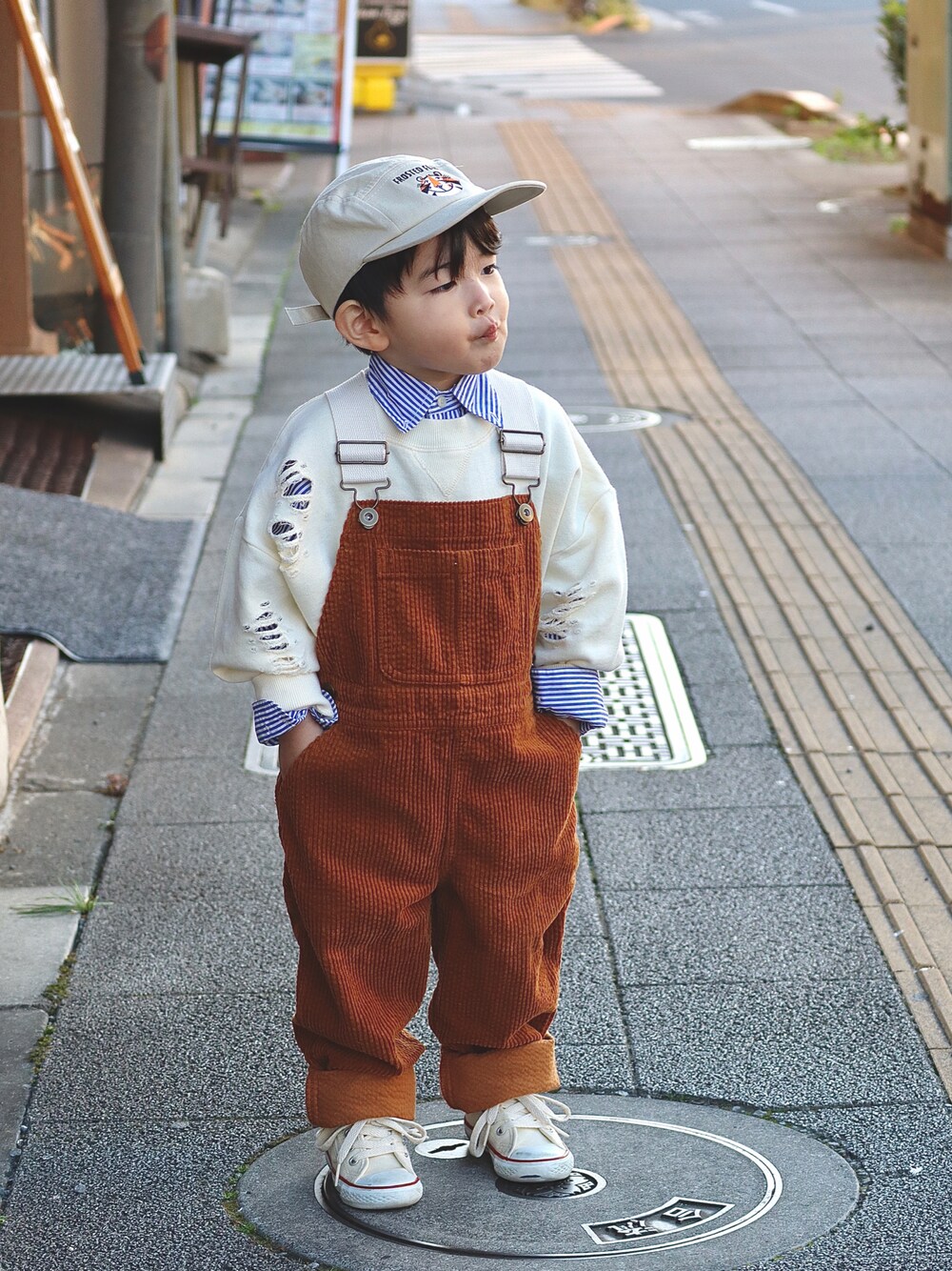 ホワイト系のスウェット、ブルー系のシャツ/ブラウス、イエロー系のサロペット/オーバーオールを着用したキッズの秋コーディネートの1枚目の写真