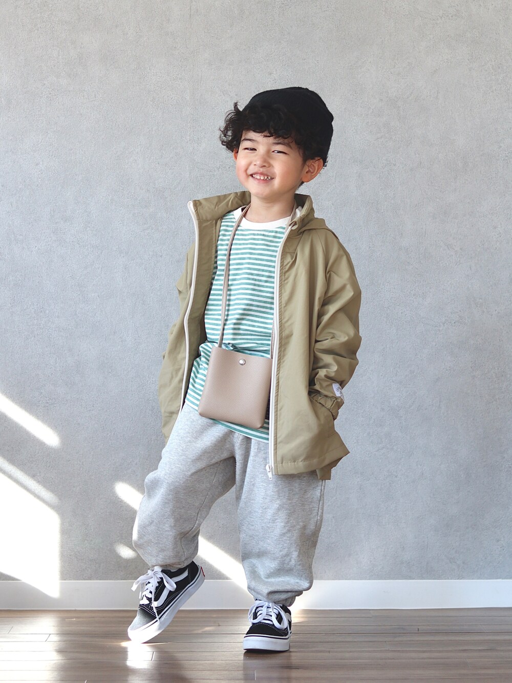 グリーン系のTシャツ/カットソー、ホワイト系のスウェットパンツ、ベージュ系のショルダーバッグを着用したキッズの冬コーディネートの1枚目の写真