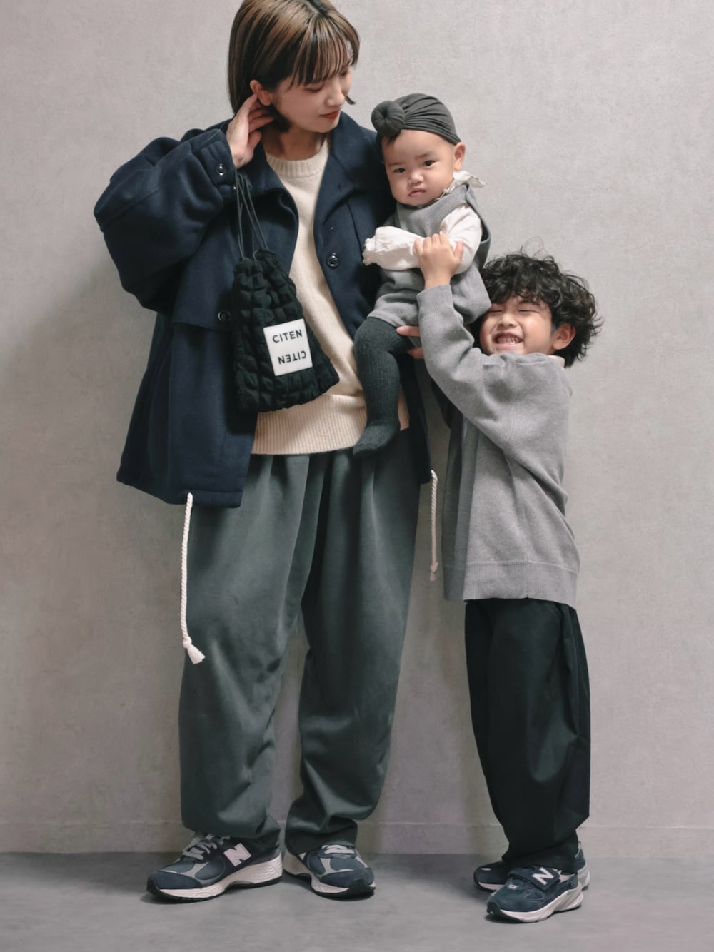 ブルー系のその他アウター、ホワイト系のニット/セーター、ブラック系のショルダーバッグを着用したキッズの秋コーディネートの1枚目の写真