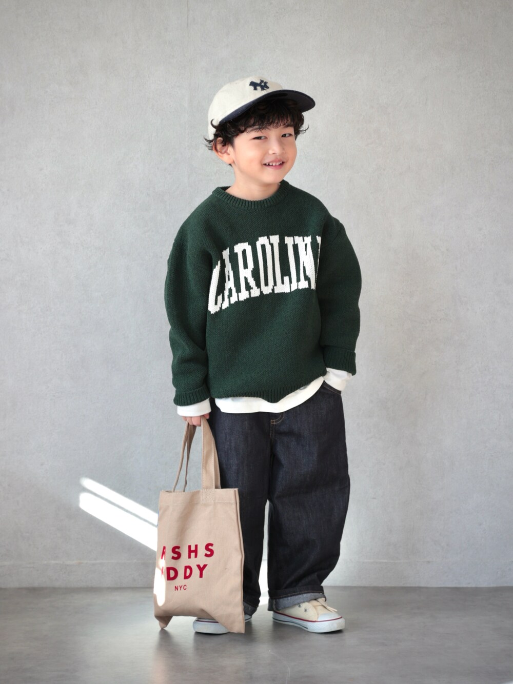 グリーン系のニット/セーター、ホワイト系のTシャツ/カットソー、ブラック系のパンツを着用したキッズの冬コーディネートの1枚目の写真