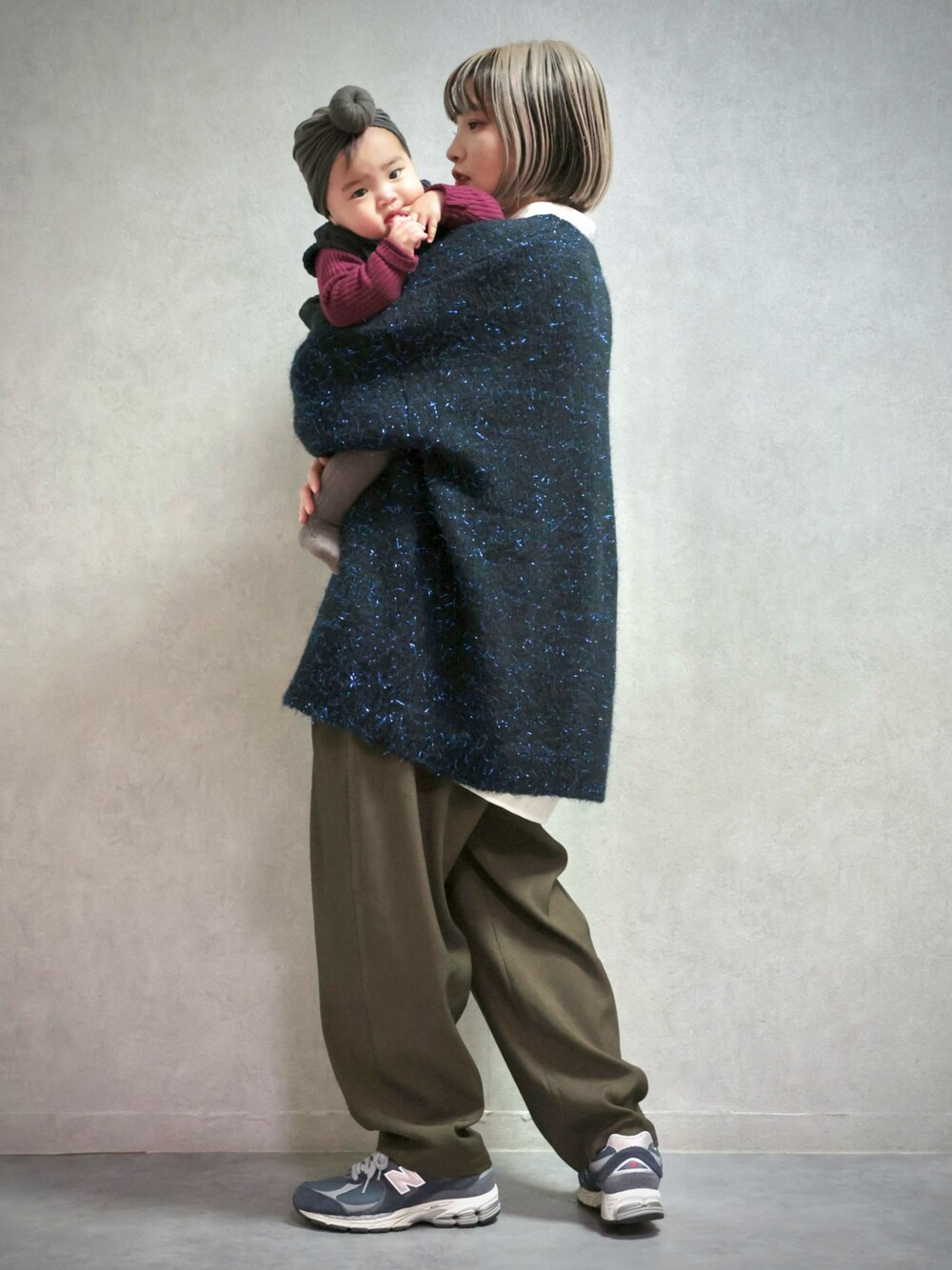 ブラック系のニット/セーター、グリーン系のスラックス、ブルー系のスニーカーを着用したキッズの冬コーディネートの1枚目の写真