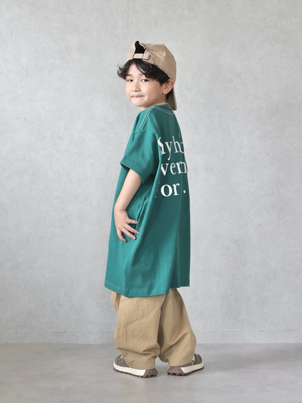 グリーン系のワンピース、ベージュ系のカーゴパンツ、ブラウン系のスニーカーを着用したキッズの夏コーディネートの1枚目の写真