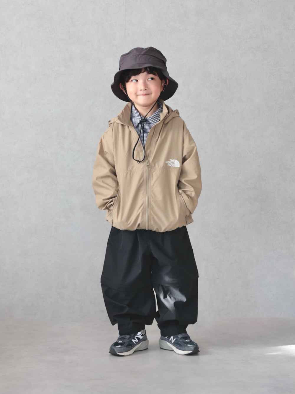 ベージュ系のブルゾン、ブルー系のシャツ/ブラウス、ブラック系のパンツを着用したキッズの冬コーディネートの1枚目の写真
