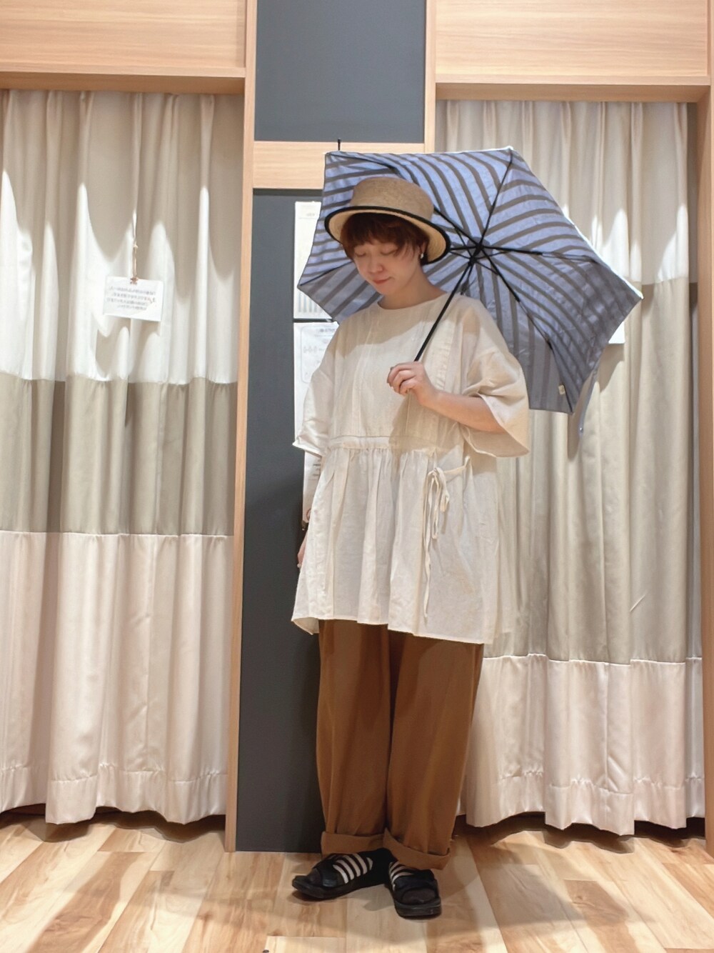 ブラウン系のパンツ、ホワイト系のシャツ/ブラウス、ブラック系のハットを着用したレディースの夏コーディネートの1枚目の写真