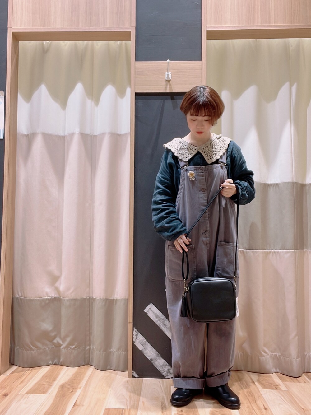 グリーン系のシャツ/ブラウス、グレー系のサロペット/オーバーオール、ブラック系のショルダーバッグを着用したレディースの秋コーディネートの1枚目の写真