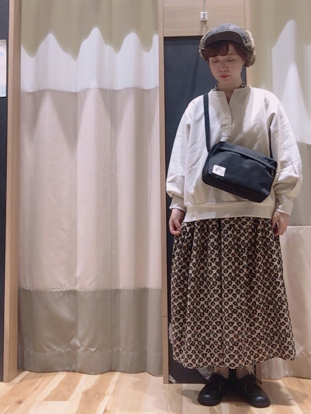 ブラック系のバッグ、ブラウン系のワンピース、ベージュ系のTシャツ/カットソーを着用したレディースの秋コーディネートの1枚目の写真