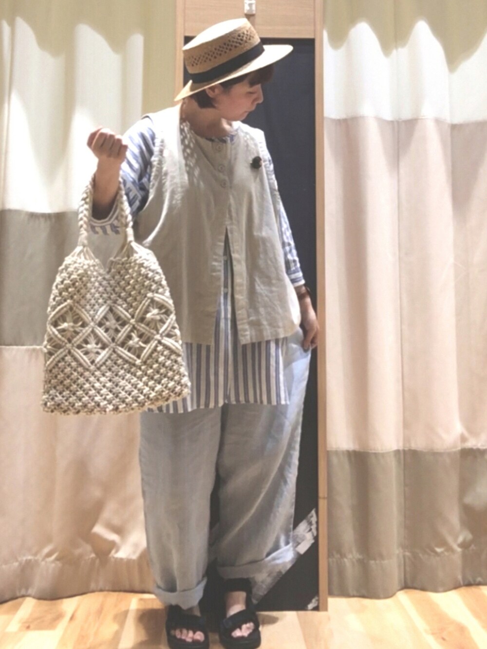 ホワイト系のトートバッグ、ベージュ系のベスト、ブルー系のシャツ/ブラウスを着用したレディースの夏コーディネートの1枚目の写真