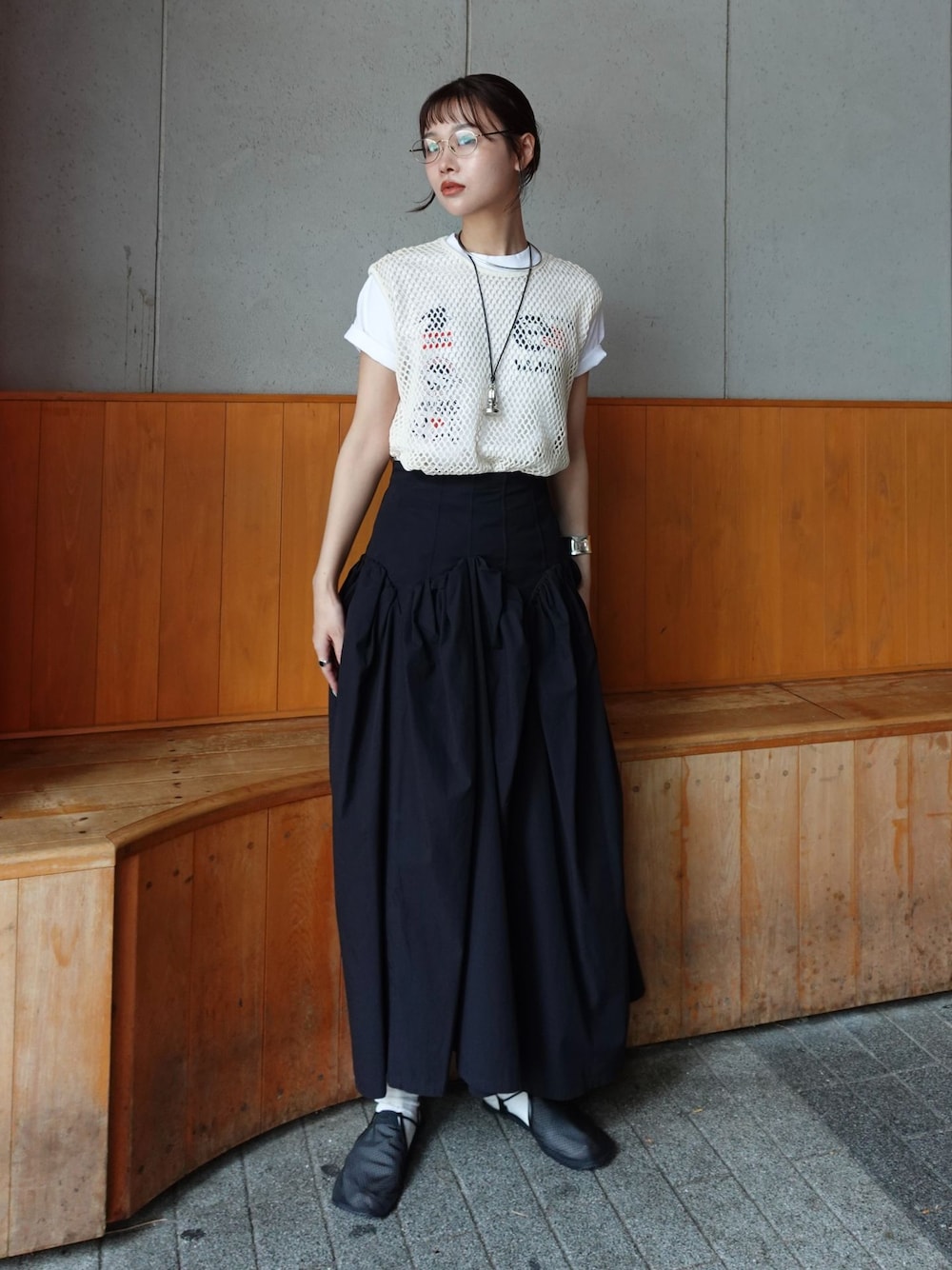 ブラック系のスカート、ベージュ系のTシャツ/カットソー、ブラック系のサンダルを着用したレディースの夏コーディネートの1枚目の写真