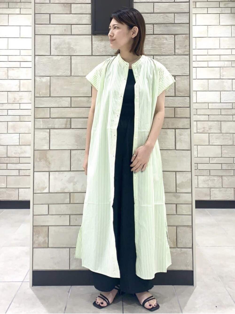 グリーン系のシャツワンピース、ブラック系のその他パンツを着用したレディースの夏コーディネートの1枚目の写真