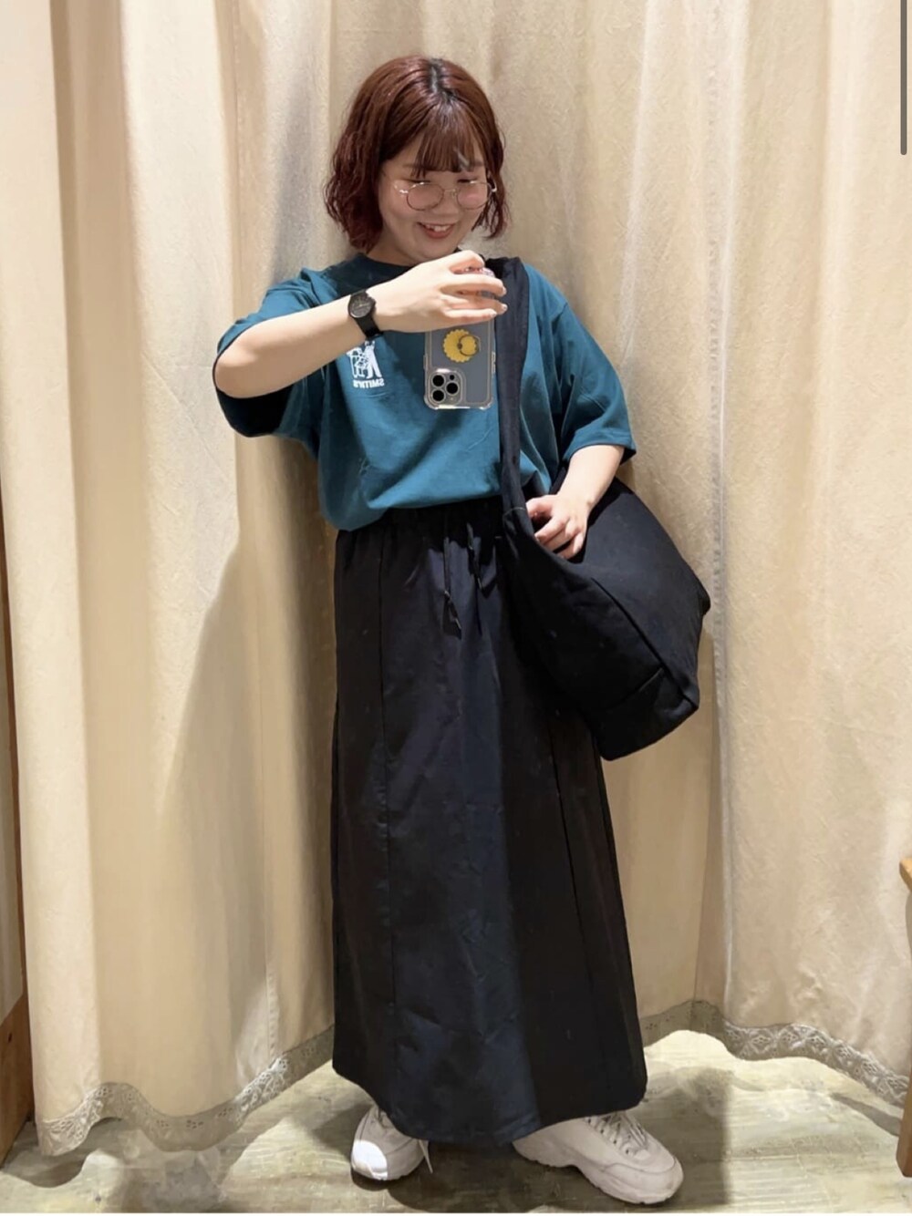 グリーン系のTシャツ/カットソー、ブラック系のスカートを着用したレディースの春コーディネートの1枚目の写真