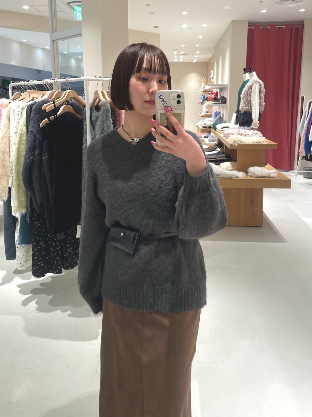 グレー系のニット/セーター、ブラウン系のスカートを着用したレディースの冬コーディネートの1枚目の写真