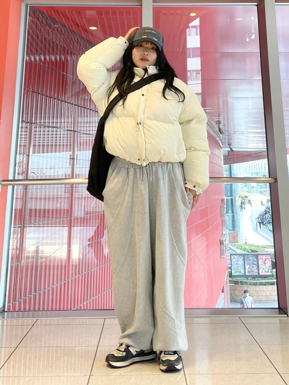 グレー系のスウェットパンツ、ブラック系のショルダーバッグ、ベージュ系のダウンジャケット/コートを着用したレディースの秋コーディネートの1枚目の写真