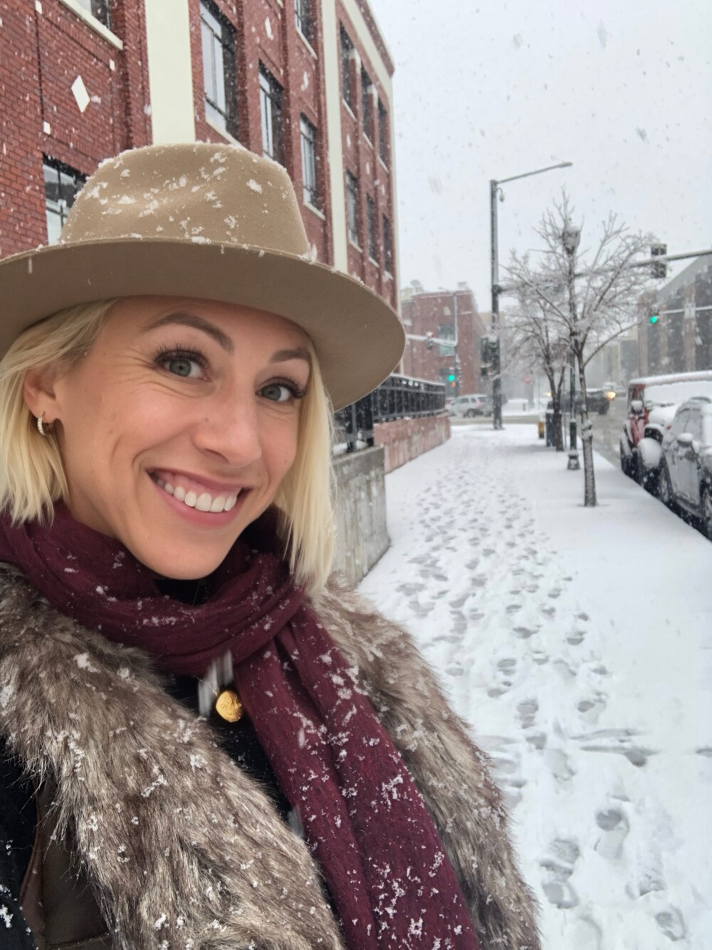 ブラウン系のベスト、ベージュ系のハット、レッド系のマフラーを着用したレディースの冬コーディネートの1枚目の写真