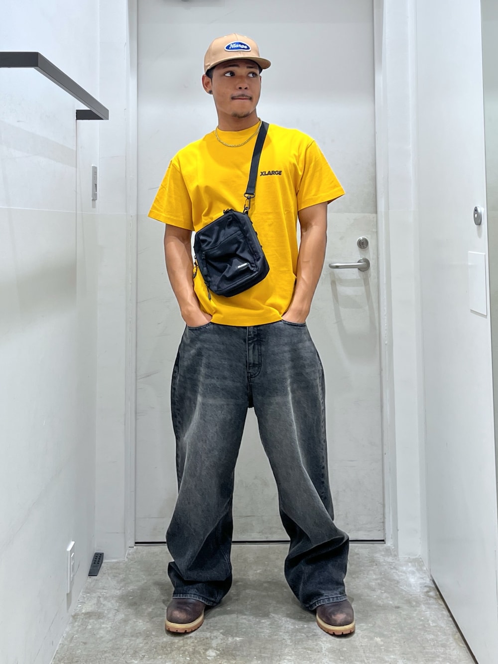 ブラック系のショルダーバッグ、ブラック系のデニムパンツ、イエロー系のTシャツ/カットソーを着用したメンズの夏コーディネートの1枚目の写真