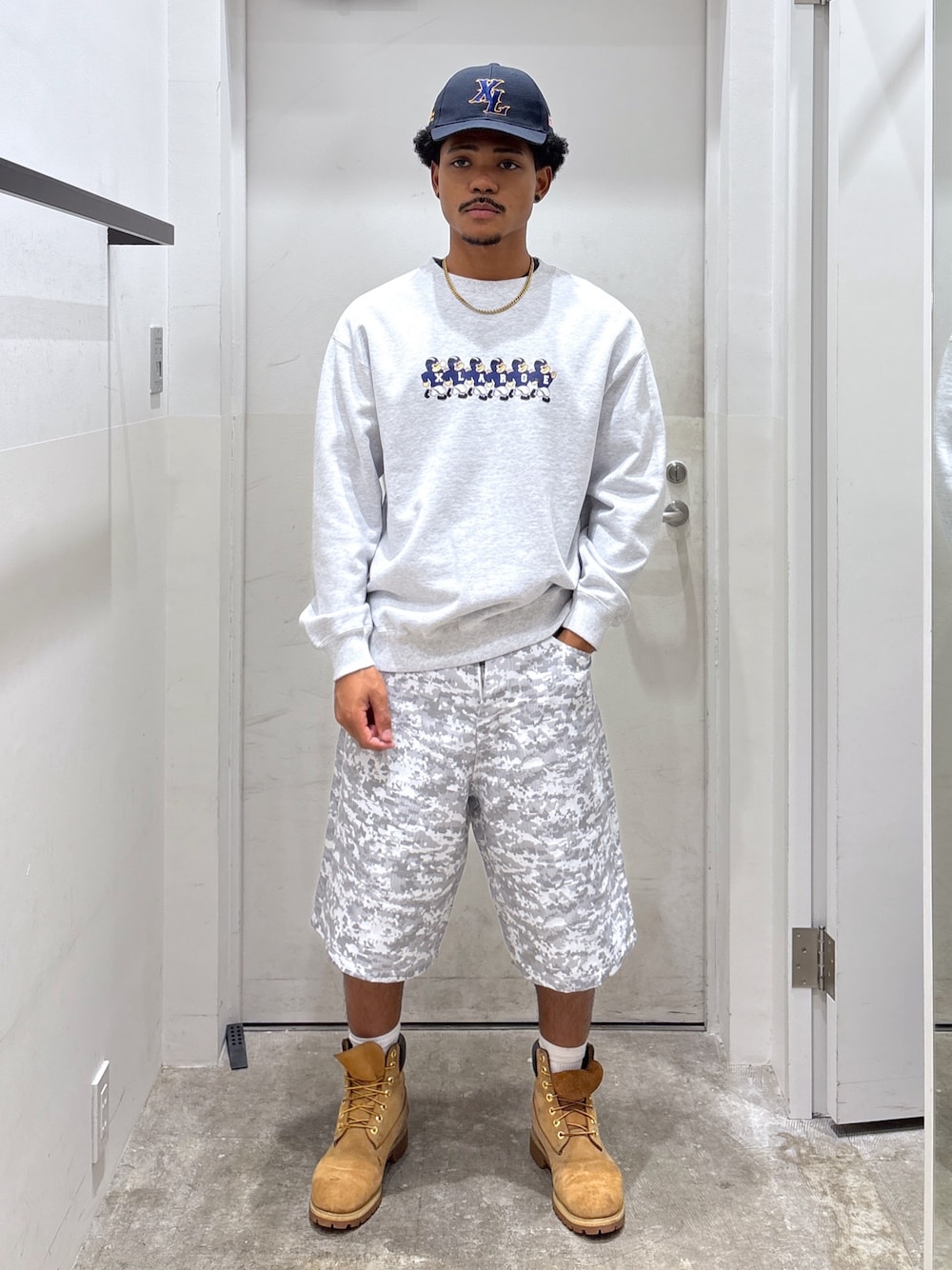 グレー系のスウェット、ホワイト系のその他パンツ、ブルー系のキャップを着用したメンズの秋コーディネートの1枚目の写真