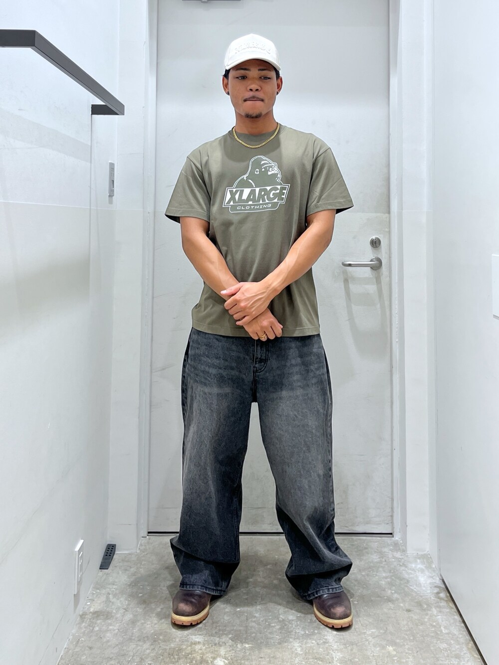 グリーン系のTシャツ/カットソー、ブラック系のデニムパンツ、ホワイト系のキャップを着用したメンズの夏コーディネートの1枚目の写真