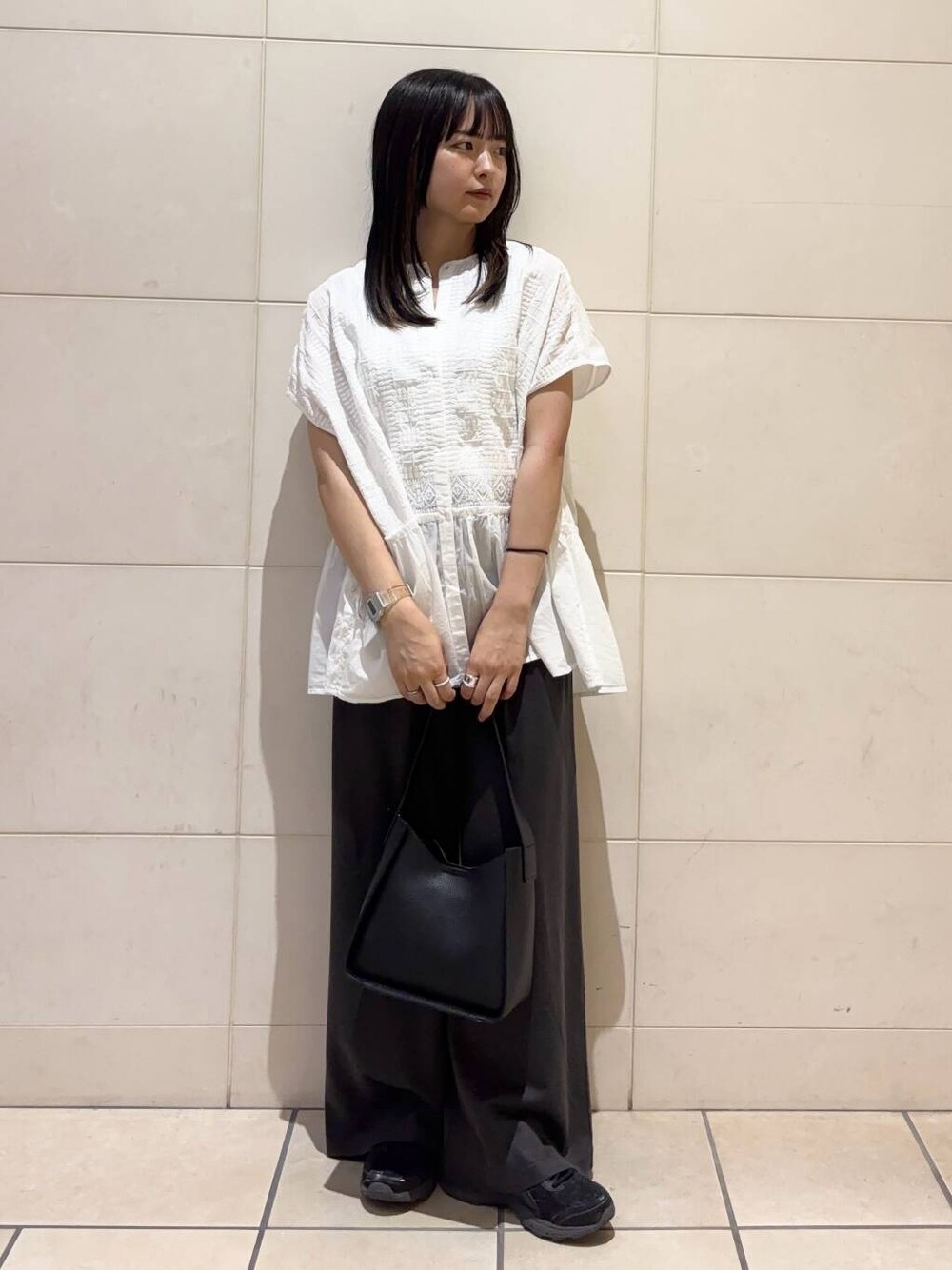 ブラック系のスニーカー、ホワイト系のシャツ/ブラウスを着用したレディースの夏コーディネートの1枚目の写真