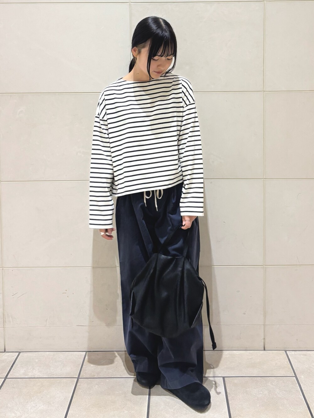 ホワイト系のTシャツ/カットソー、ブラック系のショルダーバッグ、ブラック系のサンダルを着用したレディースの夏コーディネートの1枚目の写真