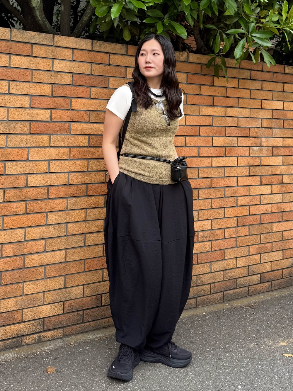 ブラック系のその他パンツ、ブラウン系のショルダーバッグ、ブラウン系のタンクトップを着用したレディースの夏コーディネートの1枚目の写真