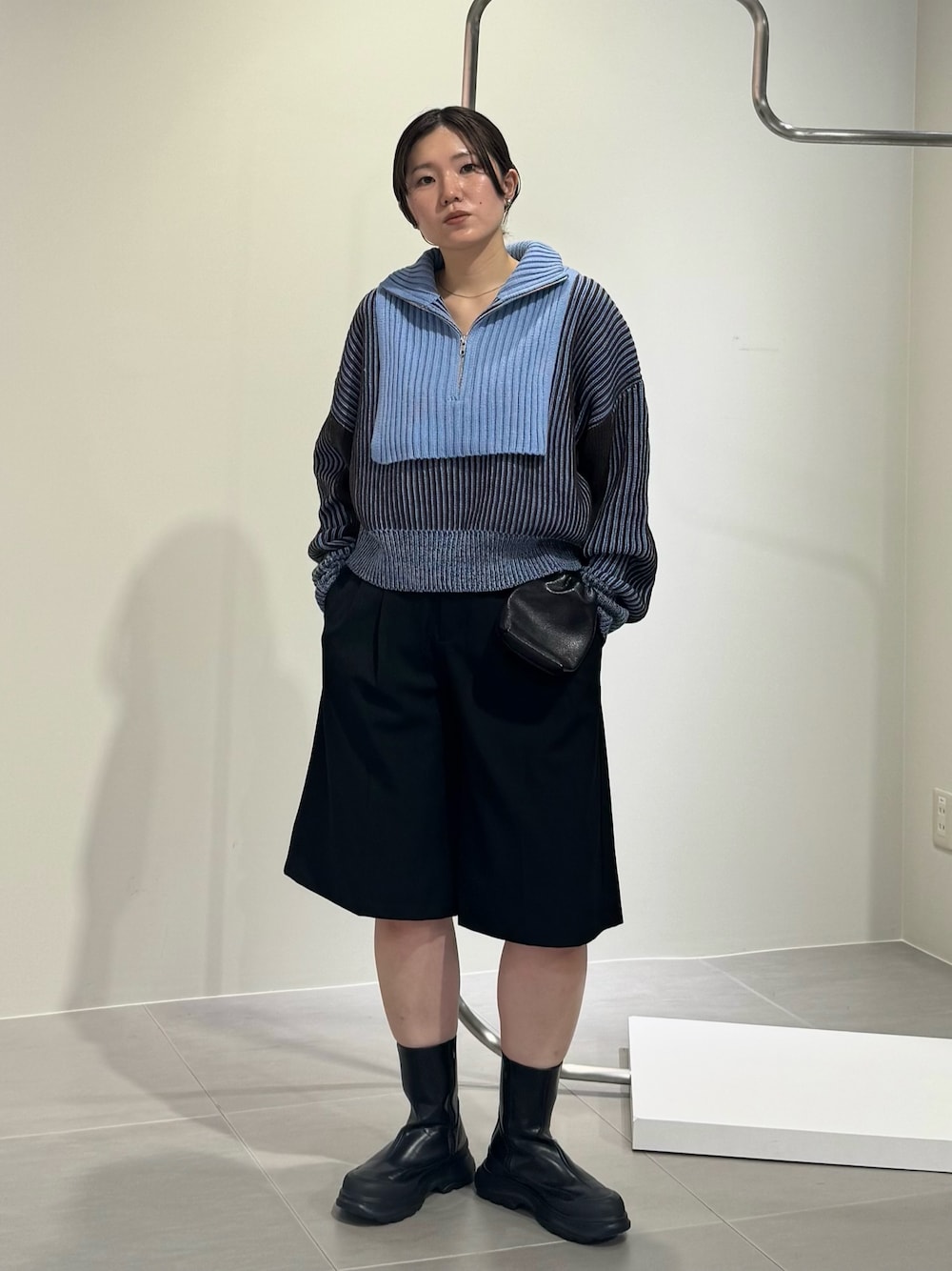 ブラック系のブーツ、ブラック系のショルダーバッグ、グレー系のニット/セーターを着用したレディースの秋コーディネートの1枚目の写真