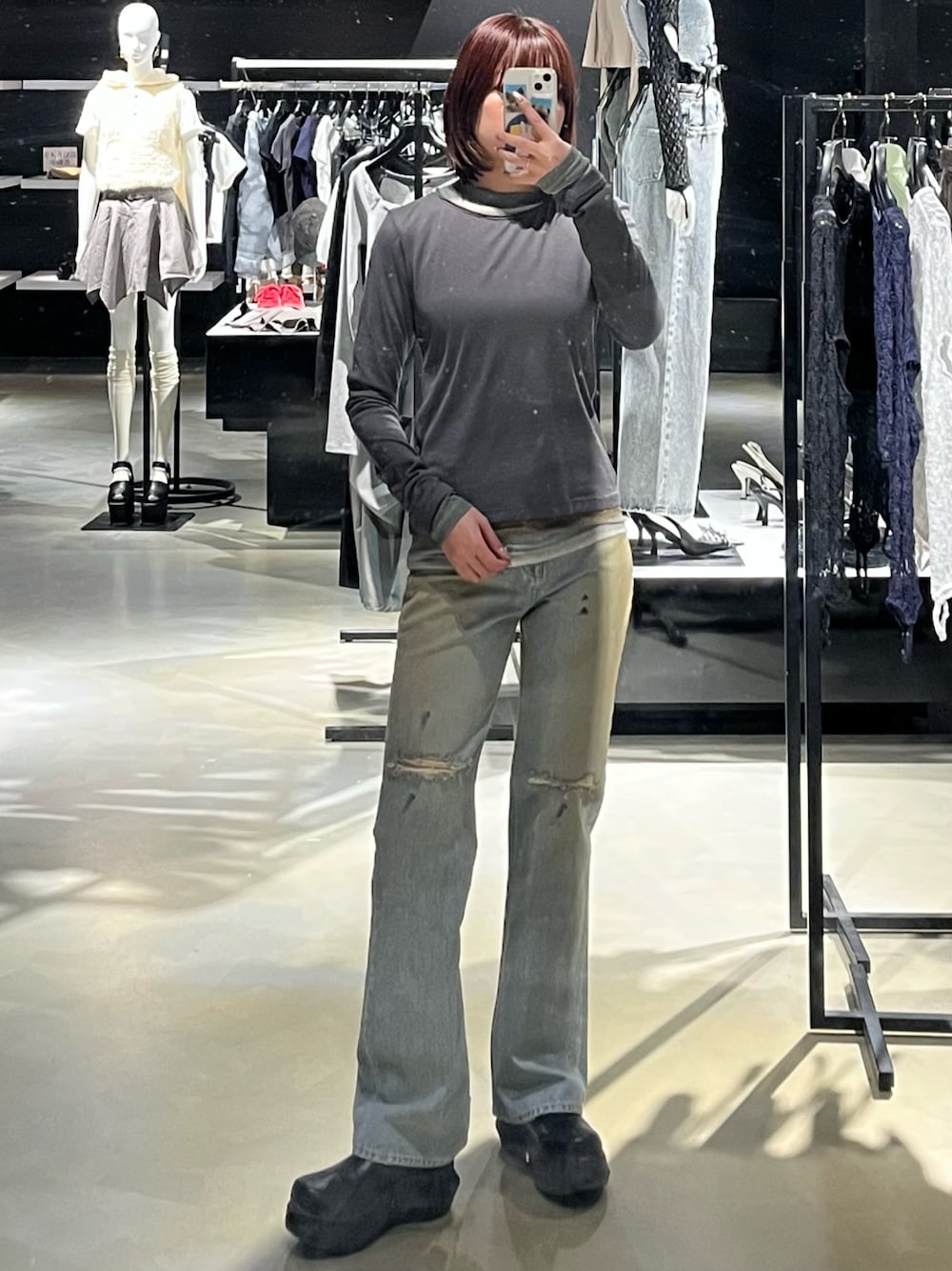 ブルー系のデニムパンツ、グレー系のTシャツ/カットソー、ブラック系のブーツを着用したレディースの春コーディネートの1枚目の写真