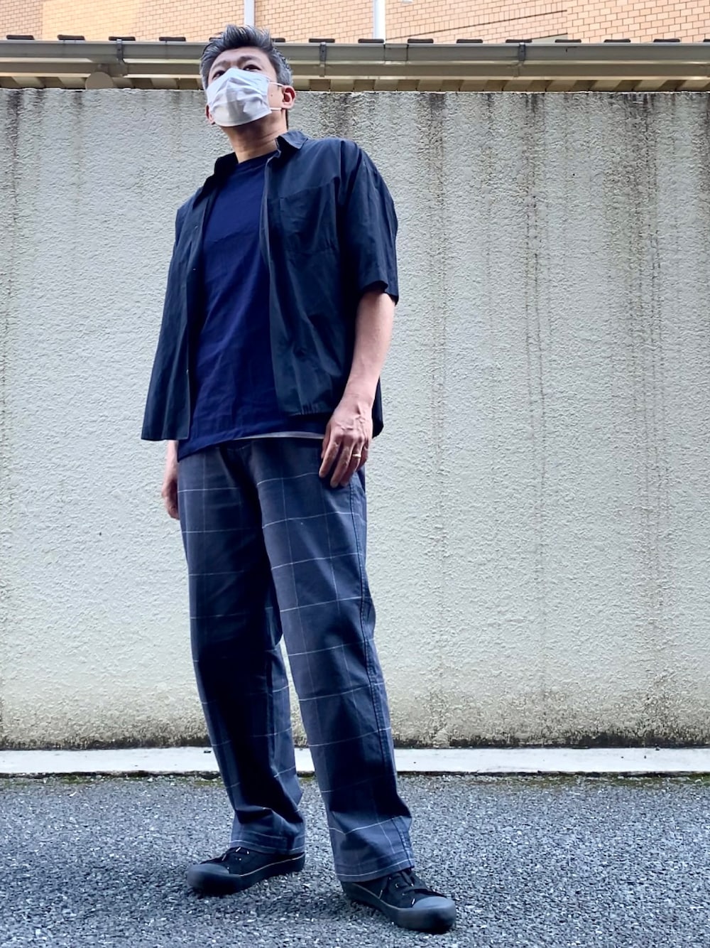 ブルー系のチノパンツ、ブラック系のスニーカー、ホワイト系のタンクトップを着用したメンズの春コーディネートの1枚目の写真