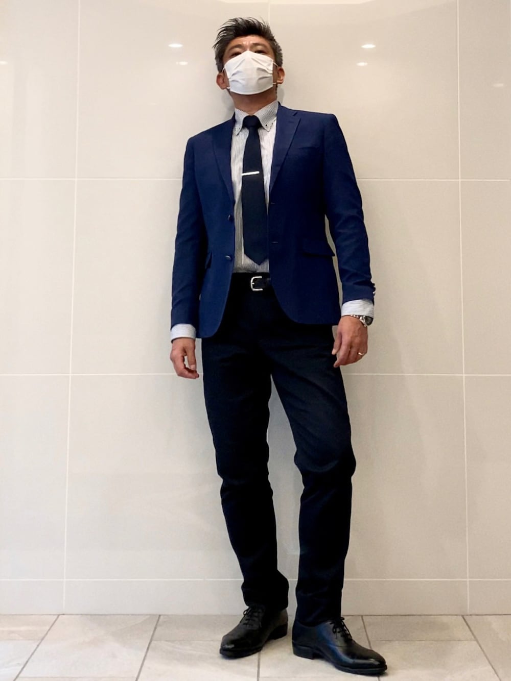 ブラック系のドレスシューズ、ブルー系のチノパンツ、ブルー系のジャケット/アウターを着用したメンズの秋コーディネートの1枚目の写真