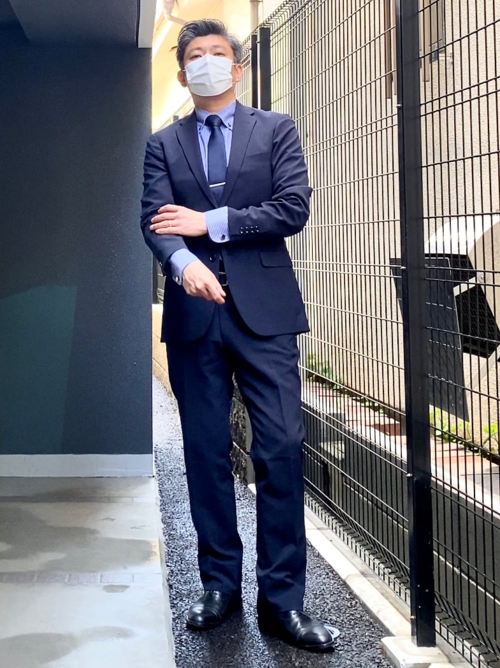 ブラック系のドレスシューズ、ブルー系のスーツセット、ブルー系のビジネスシャツを着用したメンズの春コーディネートの1枚目の写真