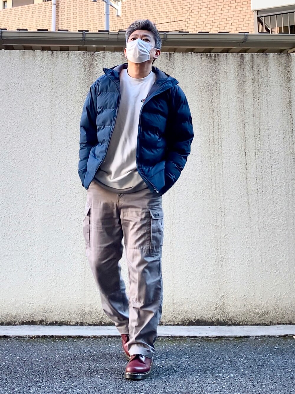 レッド系のブーツ、グレー系のカーゴパンツ、グレー系のTシャツ/カットソーを着用したメンズの冬コーディネートの1枚目の写真