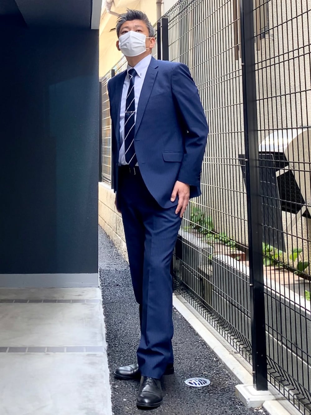 ブラック系のドレスシューズ、ブルー系のスーツセットを着用したメンズの春コーディネートの1枚目の写真