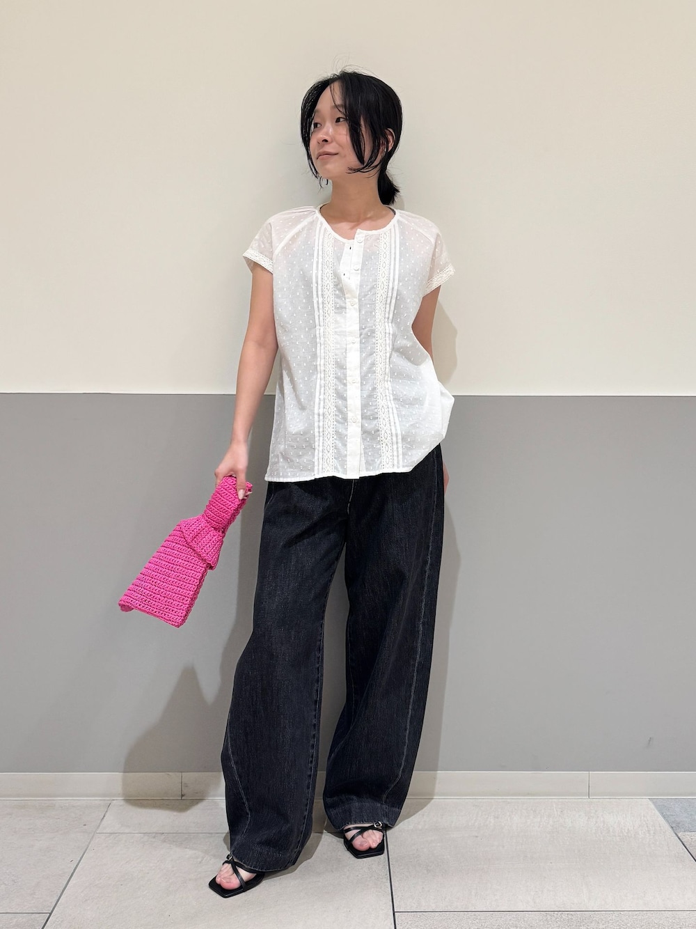ブラック系のデニムパンツ、ホワイト系のシャツ/ブラウス、ピンク系のかごバッグを着用したレディースの夏コーディネートの1枚目の写真