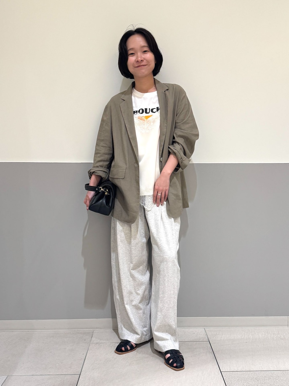 ブラウン系のテーラードジャケット、グレー系のスウェットパンツ、ホワイト系のキャミソールを着用したレディースの春コーディネートの1枚目の写真