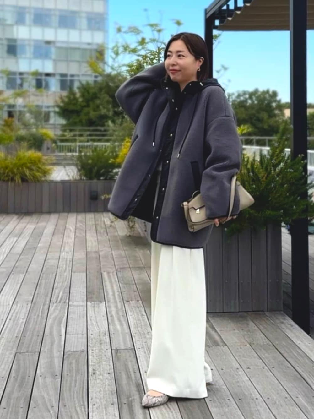 グレー系のその他アウター、ホワイト系のスラックス、グレー系のパンプスを着用したレディースの秋コーディネートの1枚目の写真