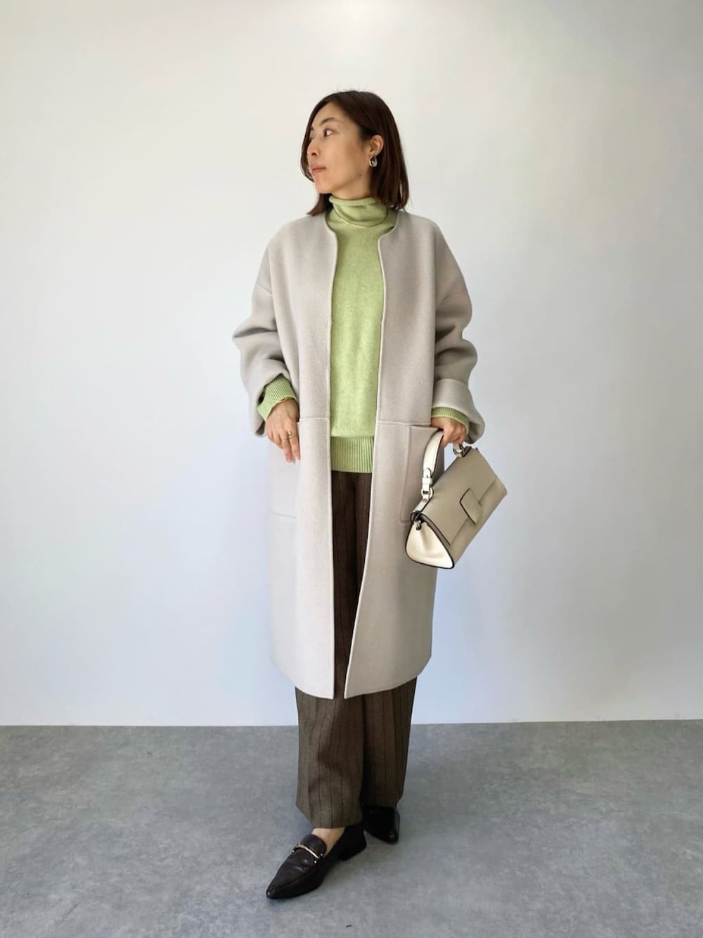 「服とコスメでなりたい自分に、冬コーデ、オトナ女子、カジュアルコーデ、シンプルコーデ、今日のコーデ、モノトーン、大人コーデ、ピスタチオ、ニット、ラフ、コート、ウールコート、ベージュコート」｜「RIVE DROITEのクリアな着映えカラーが魅力/ウール混ラグランボトルネックKN（ニット/セーター、グリーン系）」を使った、AIさん（骨格ナチュラル・レディース・160cm）の冬コーディネートの1枚目の写真