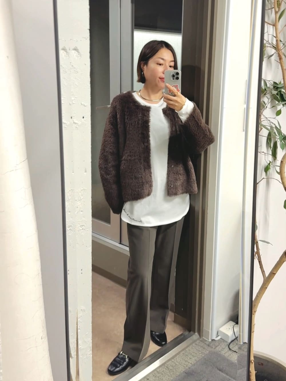 ブラウン系のカーディガン/ボレロ、ホワイト系のTシャツ/カットソー、ブラウン系のその他パンツを着用したレディースの秋コーディネートの1枚目の写真