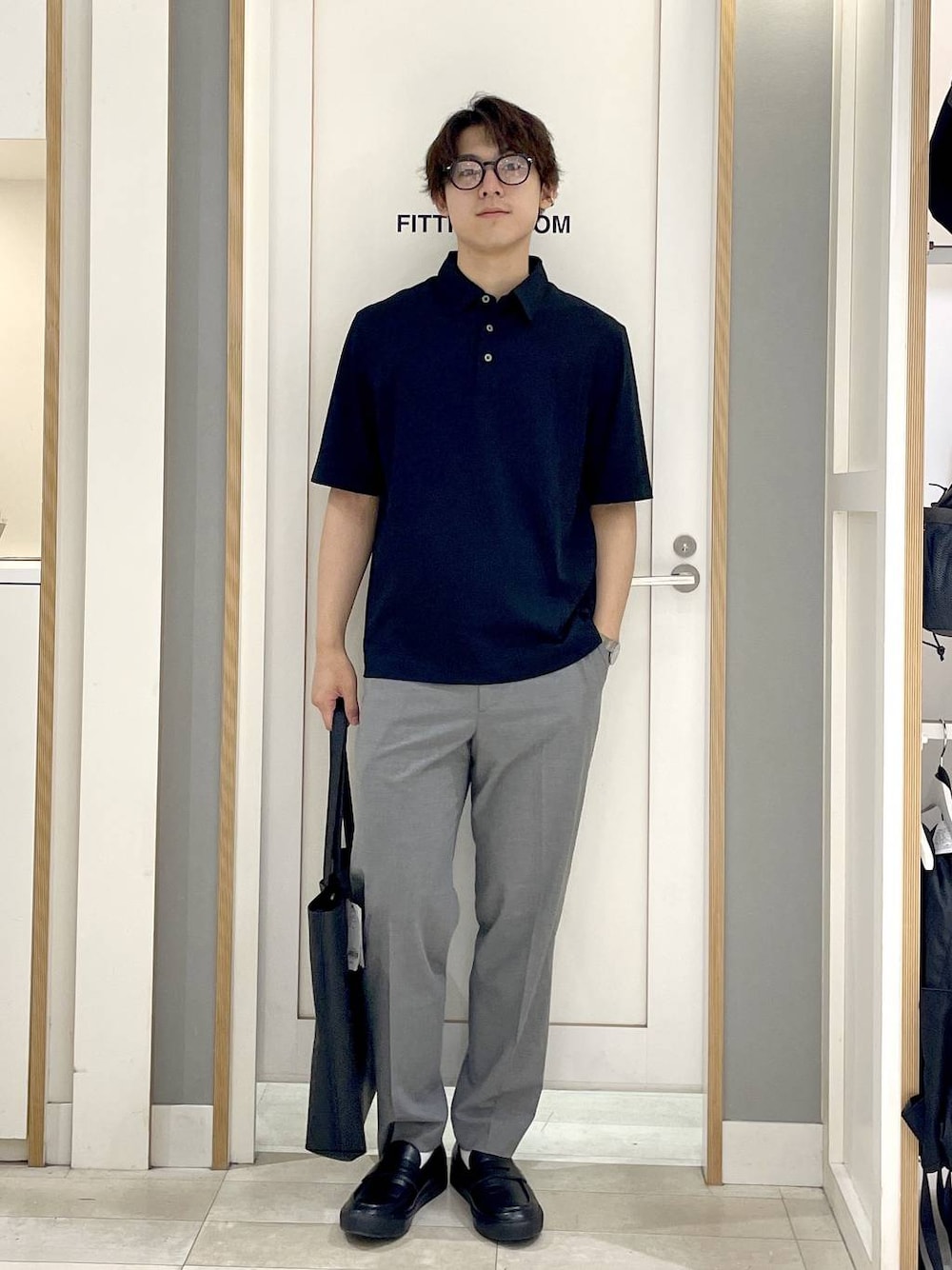 ブラック系のトートバッグ、グレー系のその他シューズ、グレー系のスラックスを着用したメンズの夏コーディネートの1枚目の写真